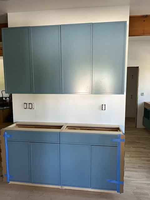 Blue base and wall cabinets installed without finishing hardware