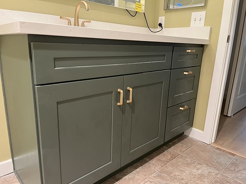 Blue Bathroom Cabinets with white countertop and gold cabinet pulls