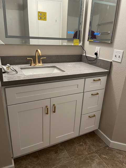 White Cabinet with Countertop and Custom Mirrors installed with Gold Cabinet Pulls