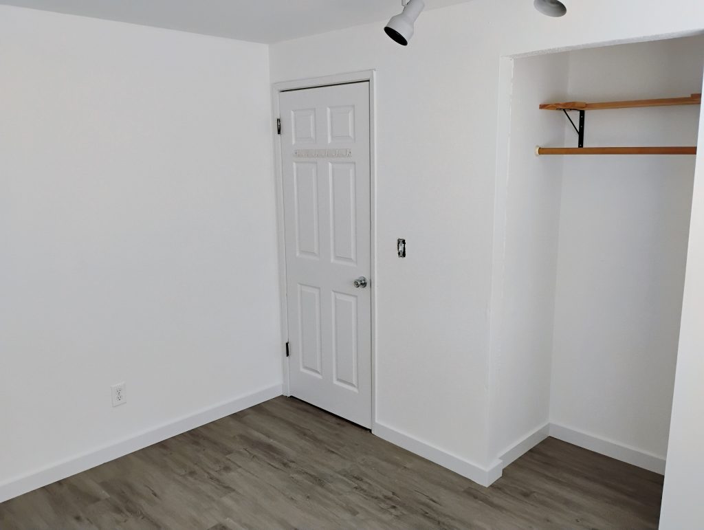 Baseboard and trim work with custom shelf in newly remodeled bedroom