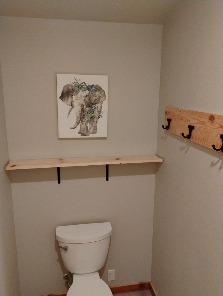 Custom shelf and towel hanger made out of cedar wood in a newly remodeled bathroom
