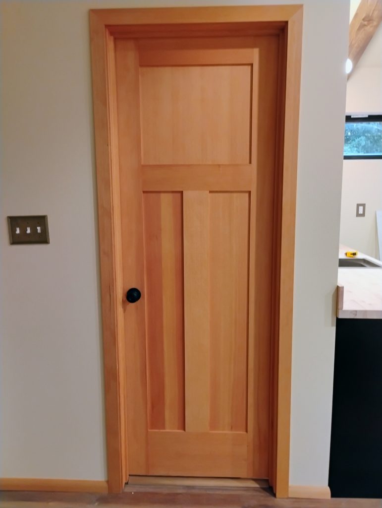 interior bathroom door with stained casing wrapped around