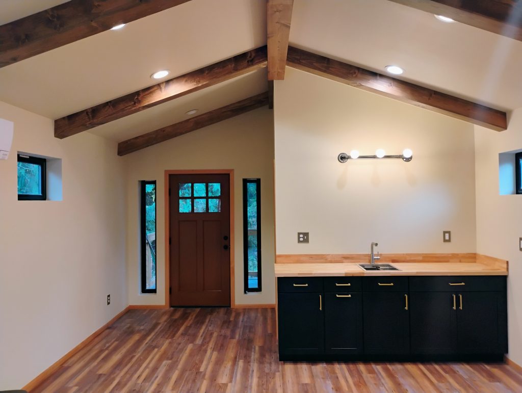 Loft Area of ADU With Cabinet, Exterior Door and Faux Beams