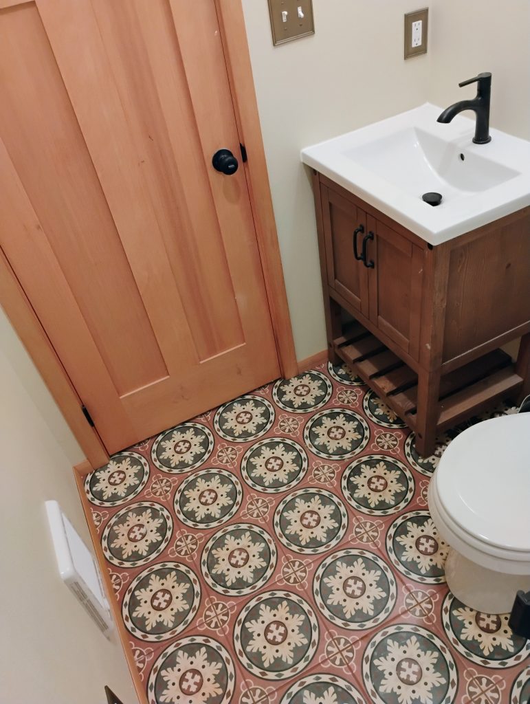 Bathroom remodel with tile flooring and new vanity toilet and door