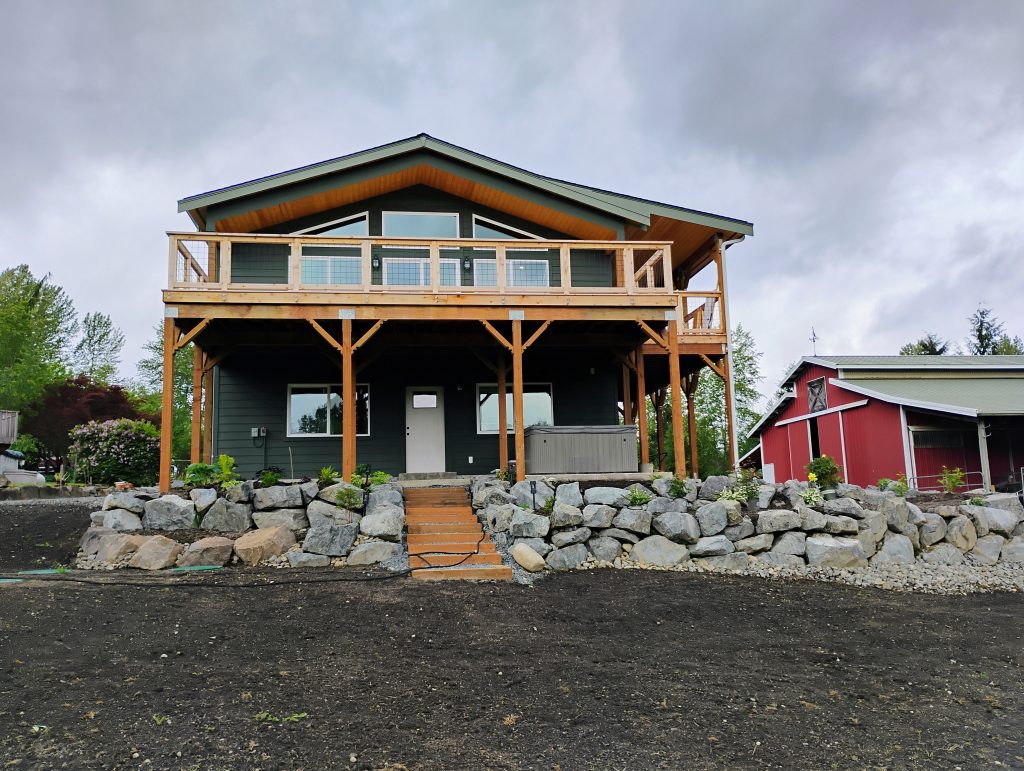 completed ADU with Rockery and deck, painted green and a exterior staircase