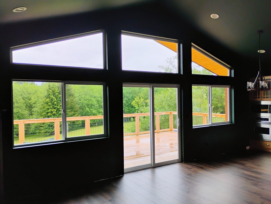 interior of house with large Windows looking out to the back deck and yard